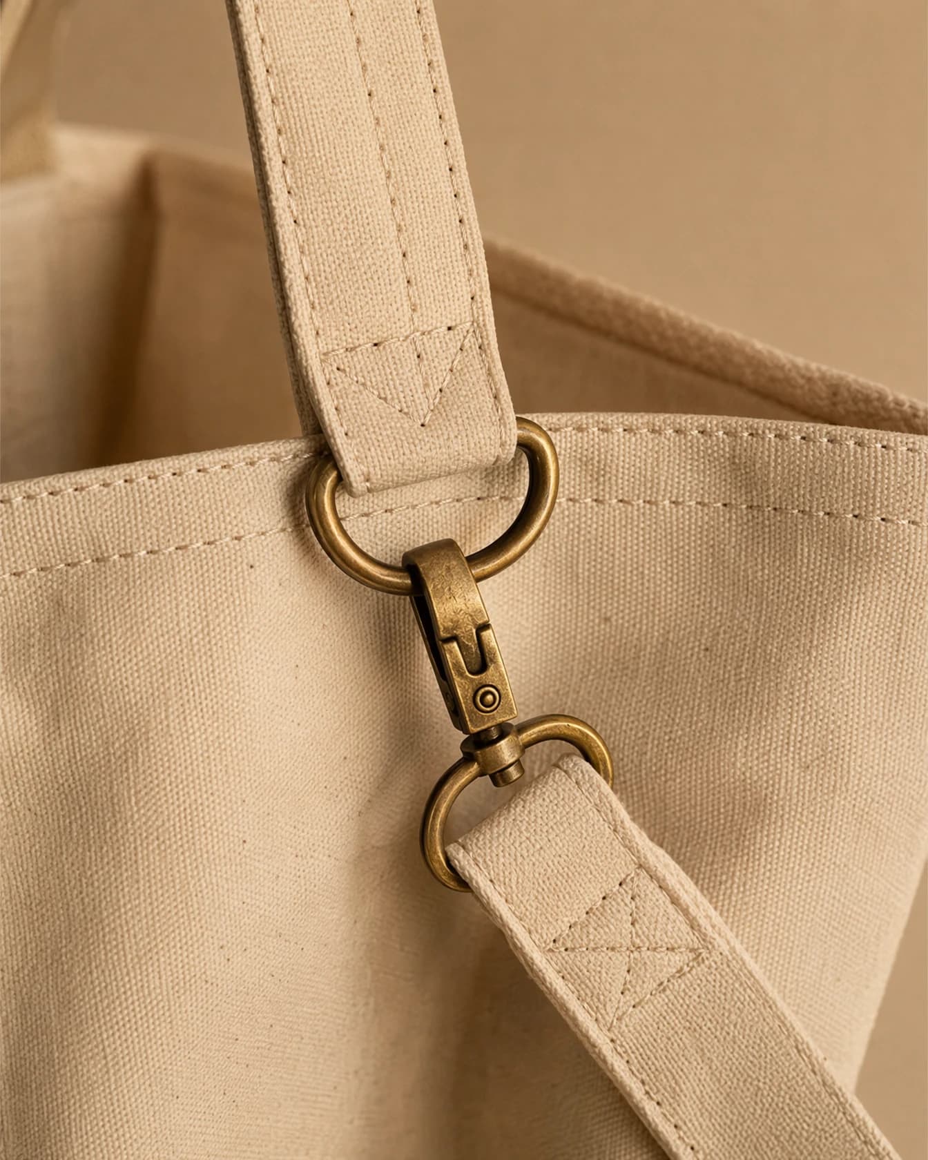Close-up of a canvas tote bag's stitched strap and hardware