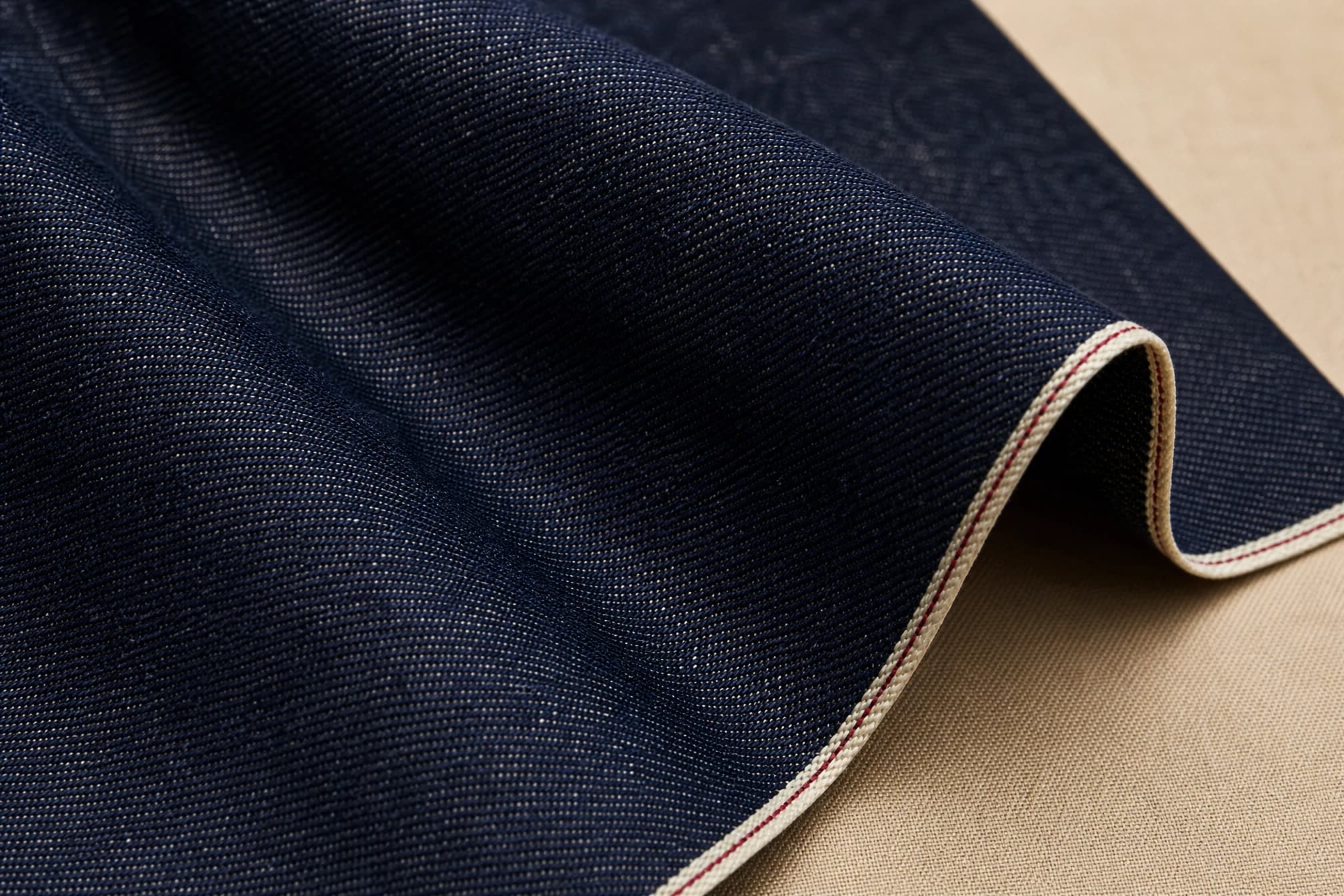 Folded raw indigo selvedge denim showing the woven texture and selvedge edge